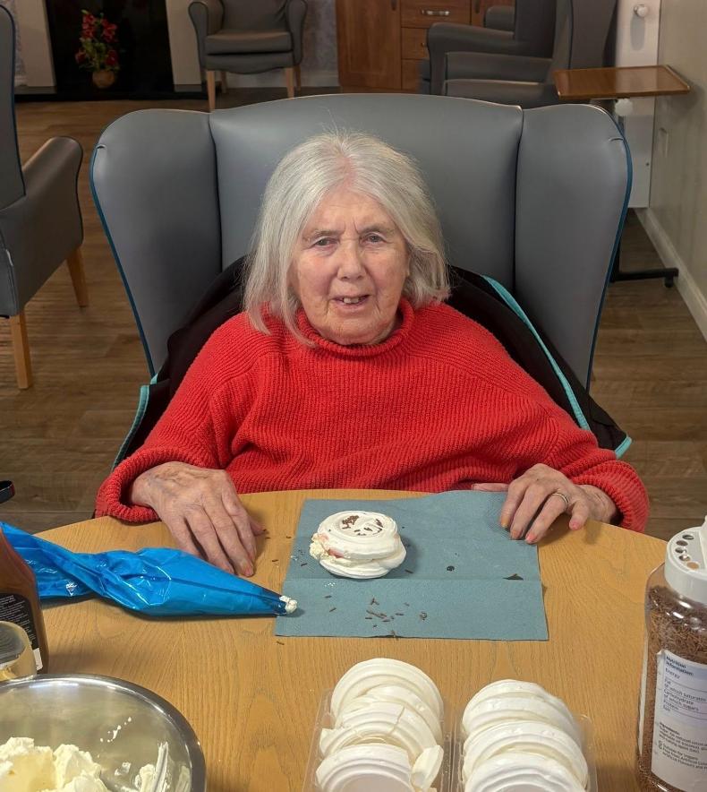 older lady in a red sweatshirt sat down with meringues