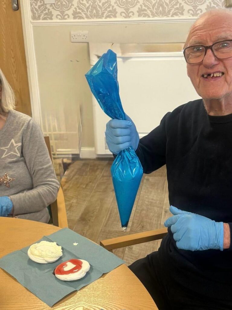 older man holding up a piping bag