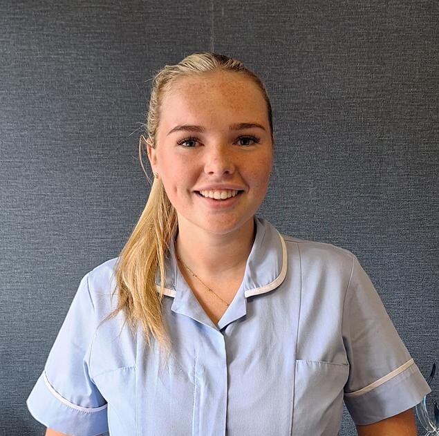 blonde woman smiling in nurse uniform