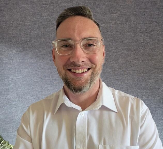 man smiling in white shirt