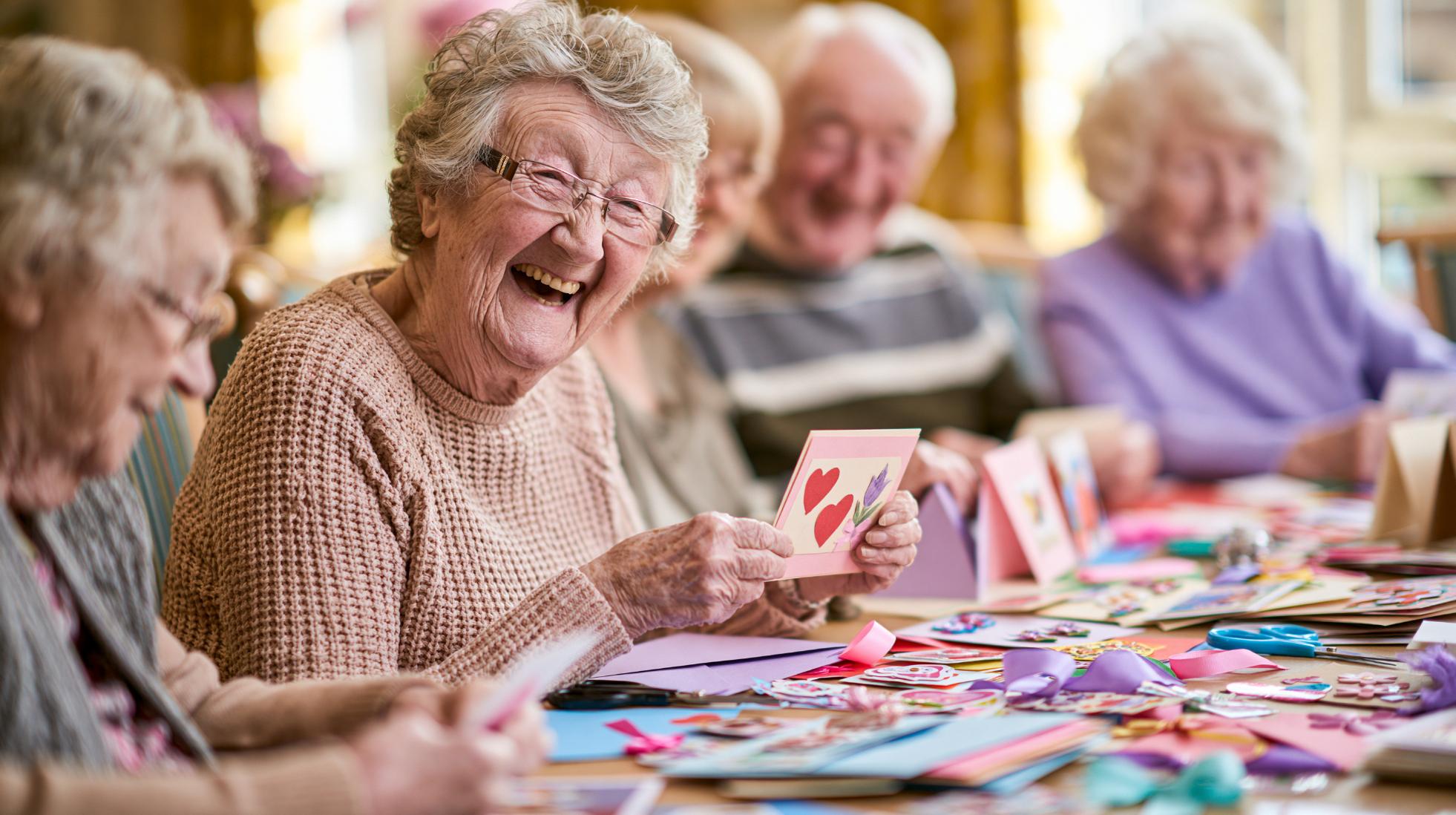 elderly woman smiling during a craft activity